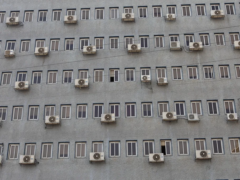 Façade de building couverte de groupes extérieurs de climatisation : l'implantation et la ventilation du condenseur conditionnent le rendement